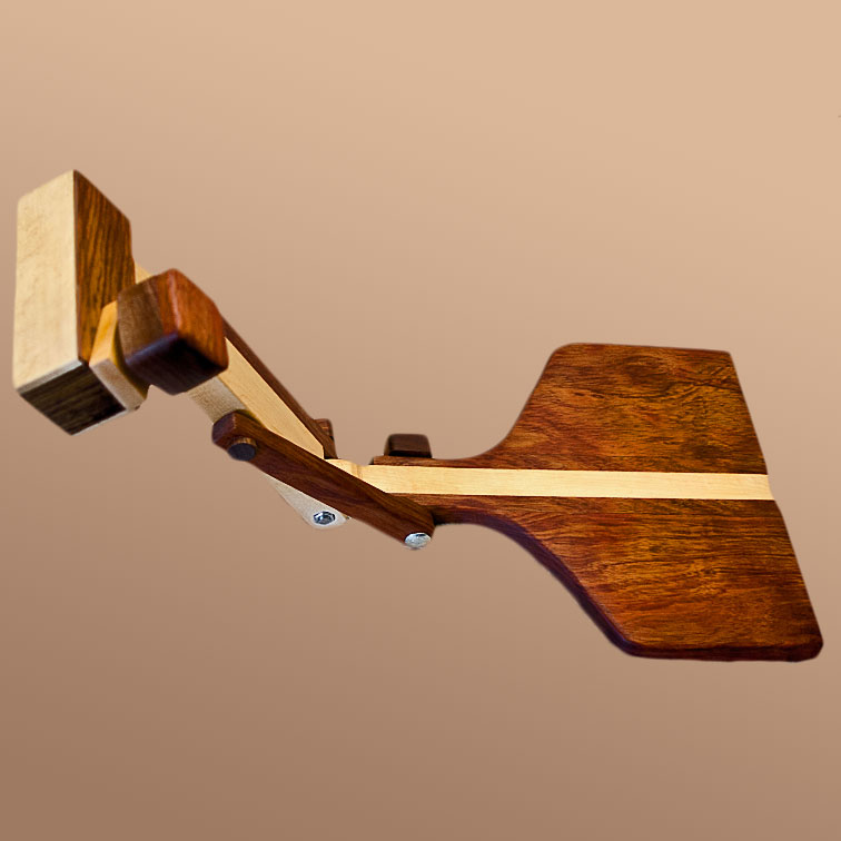 Image of a daxophone body extended on a wooden arm from a flat cutting-board-sized-base connected at a hinge and stabilization arm.