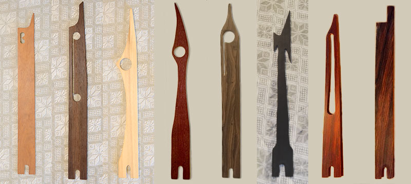 Picture of eight daxophone tongues, flat pieces of wood about 33cm long of various shapes and colors